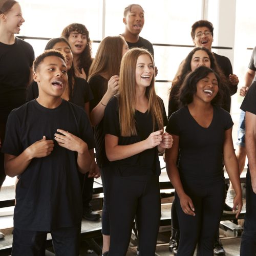 Male And Female Students Singing In Choir At Performing Arts School